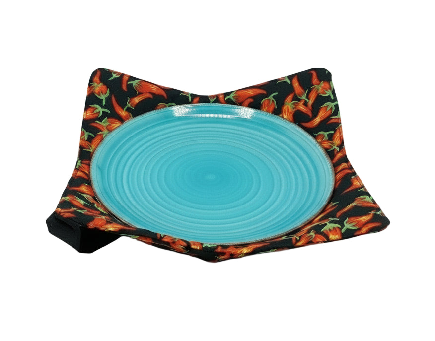 Turquoise plate on a black fabric with chili peppers
