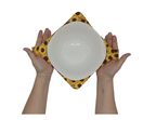 Hands holding a yellow and brown sunflower fabric bowl holder by sliding through the fabric straps on both sides