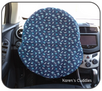 blue paw prints and white dog bones on a dark blue fabric covering a steering wheel