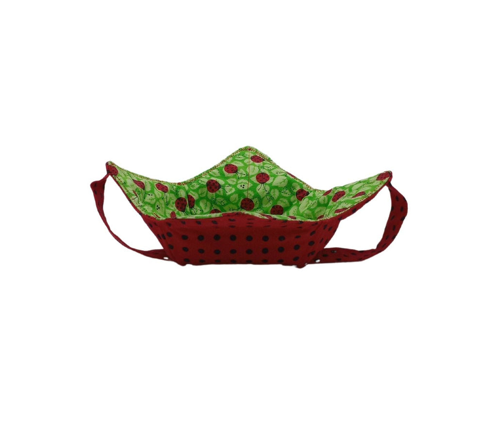bowl cozy with lady bugs and leaves on green fabric inside and black polka dots on red fabric with matching strap on outside