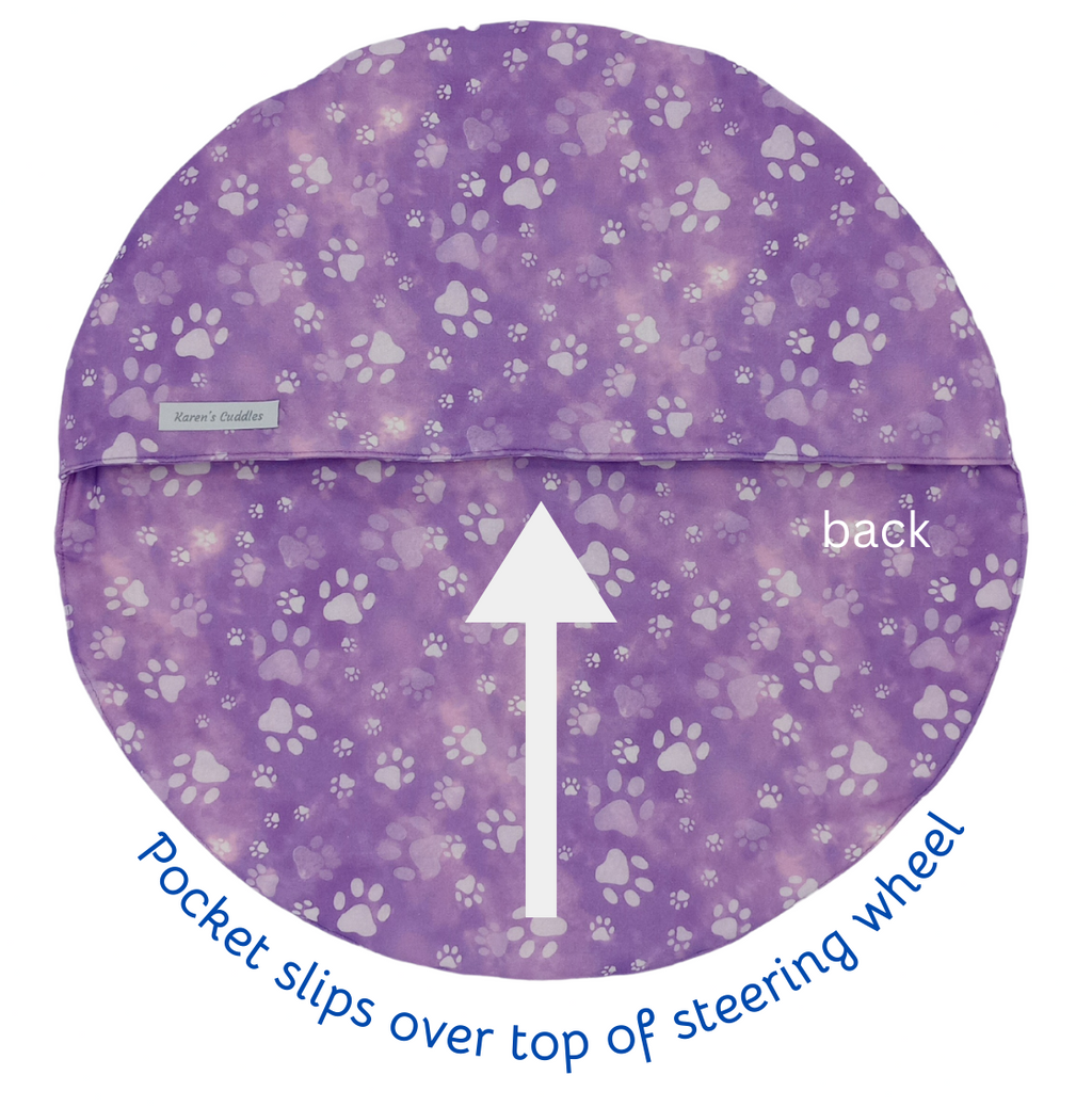 Purple steering wheel cover with paw prints and an arrow indicating the back.