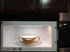 Yellow and brown sunflower fabric bowl cozy displayed inside a microwave holding a white bowl, with matching strap underneath
