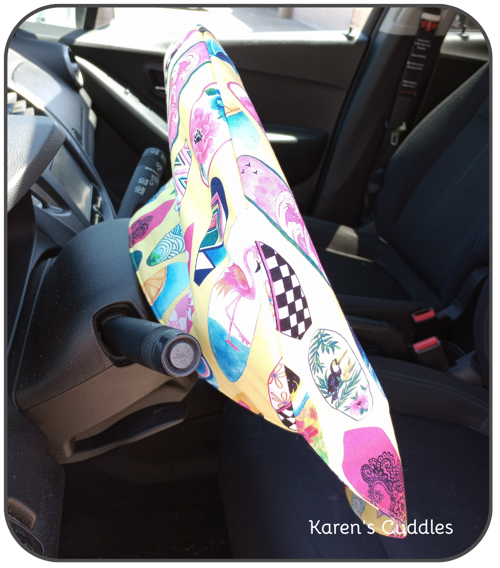 colorful surfboards on yellow fabric cover slipped over top of steering wheel